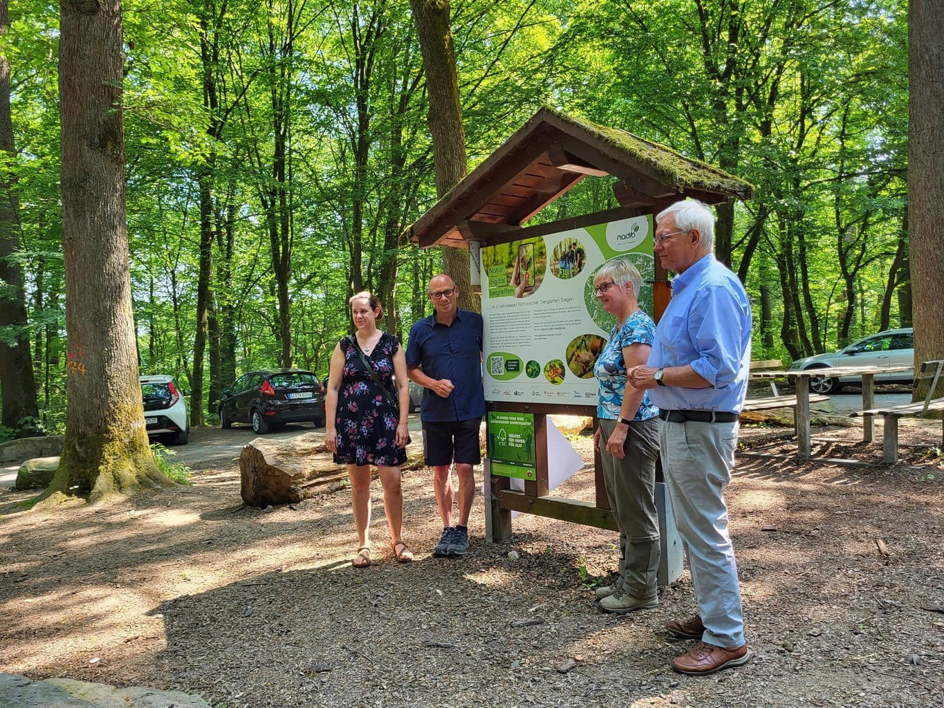 Jasmin Mantilla, Arno Wied, Klaudia Witte und Eckhard Uhlenberg enthüllen feierlich die große Informationstafel am Wanderparkplatz Grillhütte im Siegener Stadtwald